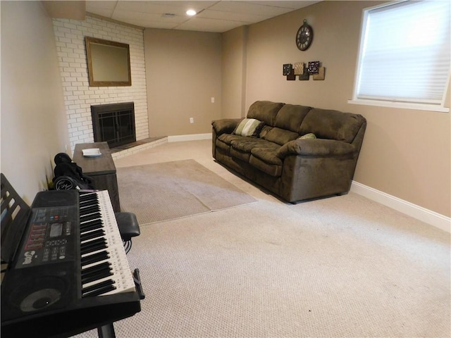 living area with baseboards, carpet floors, a brick fireplace, and a paneled ceiling