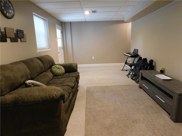 living room featuring carpet flooring and a drop ceiling