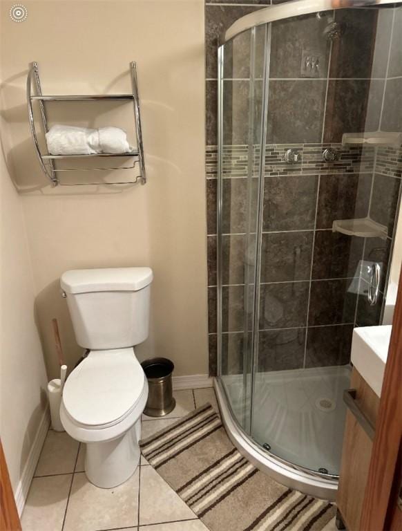 full bath with a shower stall, baseboards, toilet, vanity, and tile patterned floors
