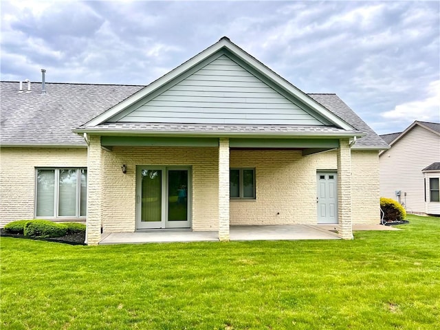 back of property featuring a patio area, a yard, and brick siding