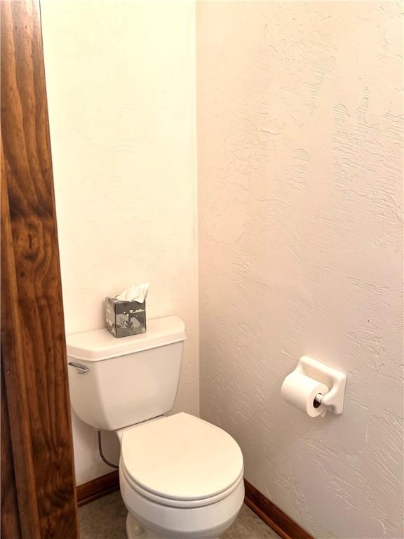bathroom with baseboards and toilet