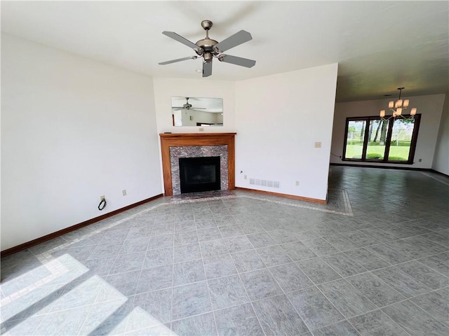 unfurnished living room with baseboards, a chandelier, a tile fireplace, ceiling fan, and tile patterned flooring
