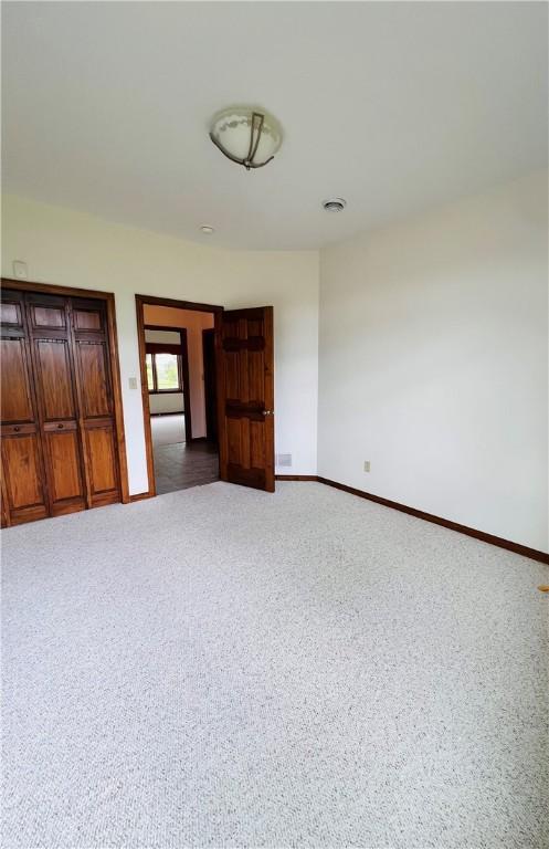 carpeted empty room featuring baseboards