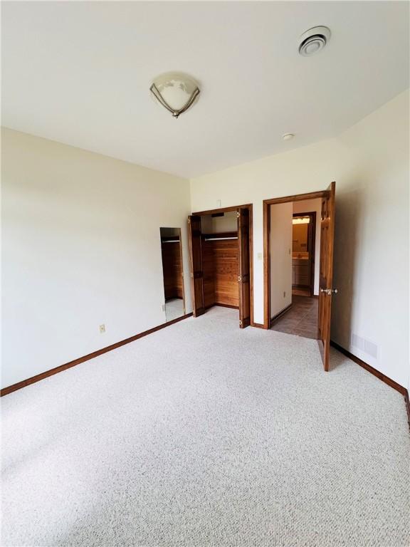 unfurnished bedroom with light carpet and baseboards