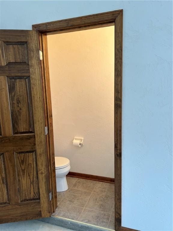 bathroom featuring baseboards and toilet