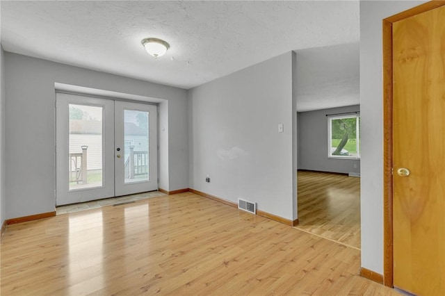 907 3rd St, Baden, PA 15005 - unfurnished room featuring french doors, light wood finished floors, baseboards, and a textured ceiling