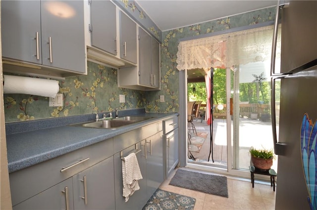 43 Bellevue Ave, West View, PA 15229 - kitchen featuring wallpapered walls, gray cabinetry, a sink, light tile patterned flooring, and dark countertops