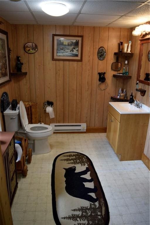 333 Baum Rd, Derry Twp, PA 15627 - bathroom with baseboard heating, tile patterned floors, toilet, wood walls, and vanity