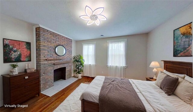 912 N Saint Clair St, Highland Park, PA 15206 - bedroom featuring wood finished floors and a brick fireplace