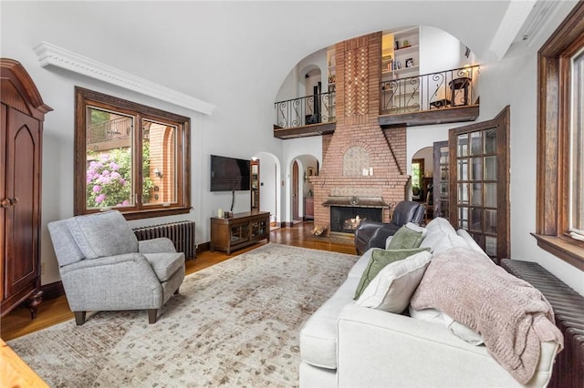 218 Barth Ave, Mt Lebanon, PA 15228 - living area with radiator, wood finished floors, a brick fireplace, arched walkways, and baseboards