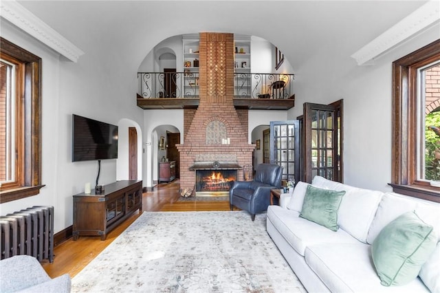 218 Barth Ave, Mt Lebanon, PA 15228 - living area featuring radiator heating unit, a brick fireplace, wood finished floors, and baseboards