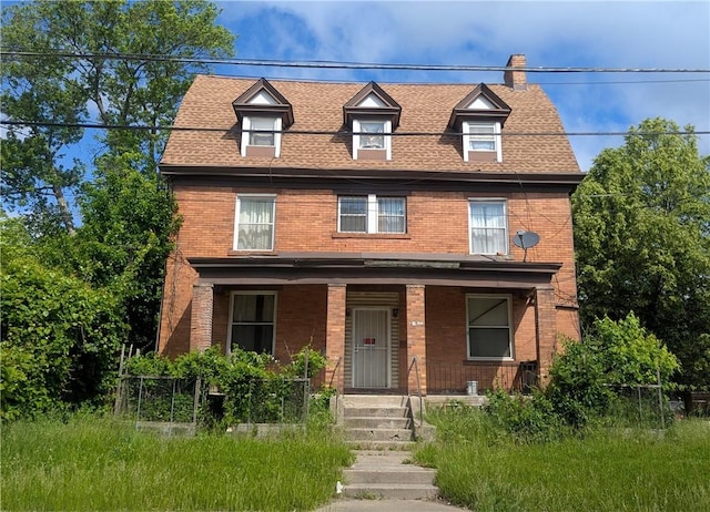 315 Lowell St, East Liberty, PA 15206 - view of front of property with brick siding, a porch, a shingled roof, and a chimney