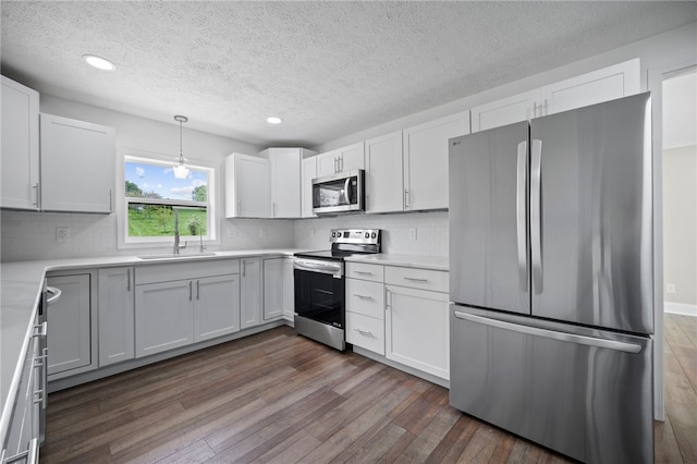 44 Heritage Hills Rd, South Union Twp, PA 15401 - kitchen featuring stainless steel appliances, a sink, dark wood finished floors, a textured ceiling, and tasteful backsplash