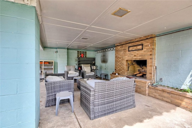 9 Forest Ave, City Of Greensburg, PA 15601 - living area with concrete flooring, a brick fireplace, and concrete block wall
