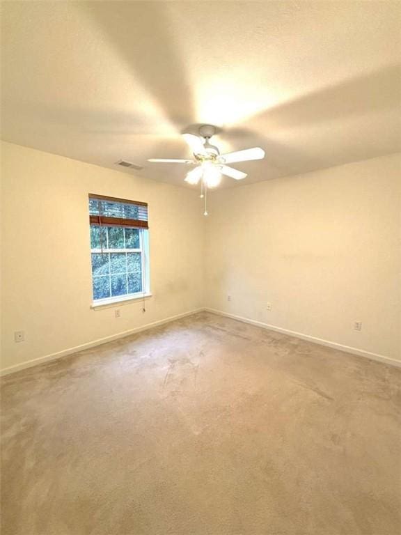 spare room with baseboards, a ceiling fan, and carpet