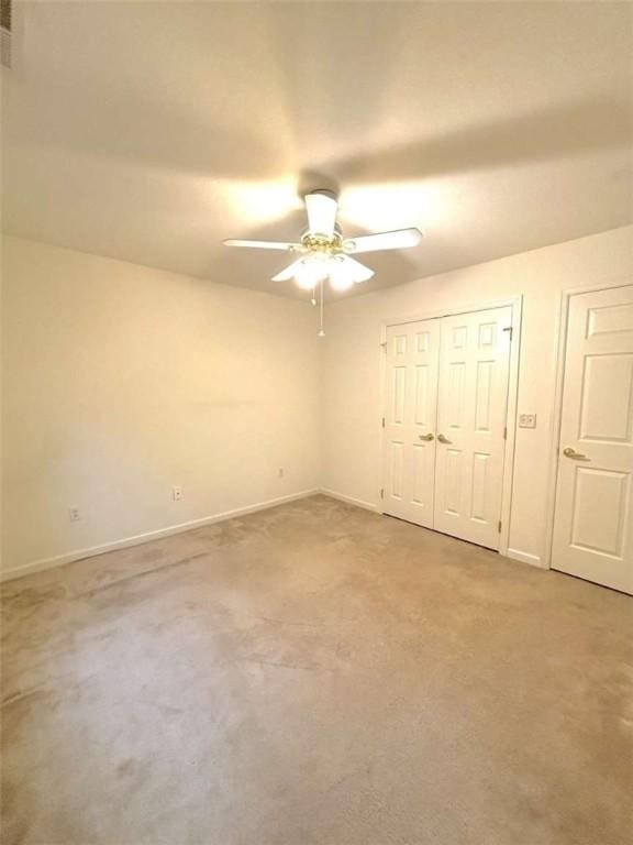 unfurnished bedroom featuring carpet floors, baseboards, and a ceiling fan