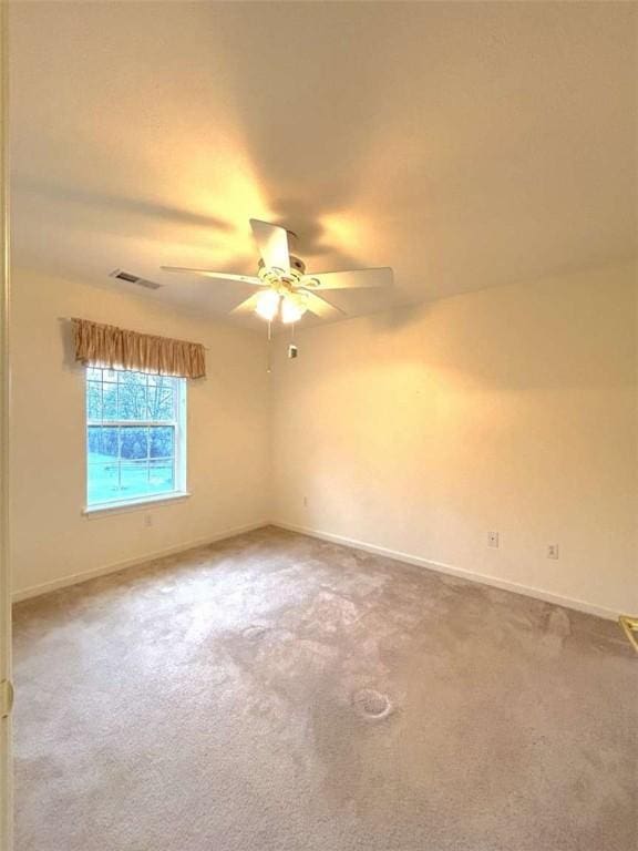 empty room with ceiling fan, carpet, and baseboards