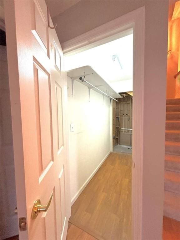 hall with wood finished floors, stairway, and baseboards