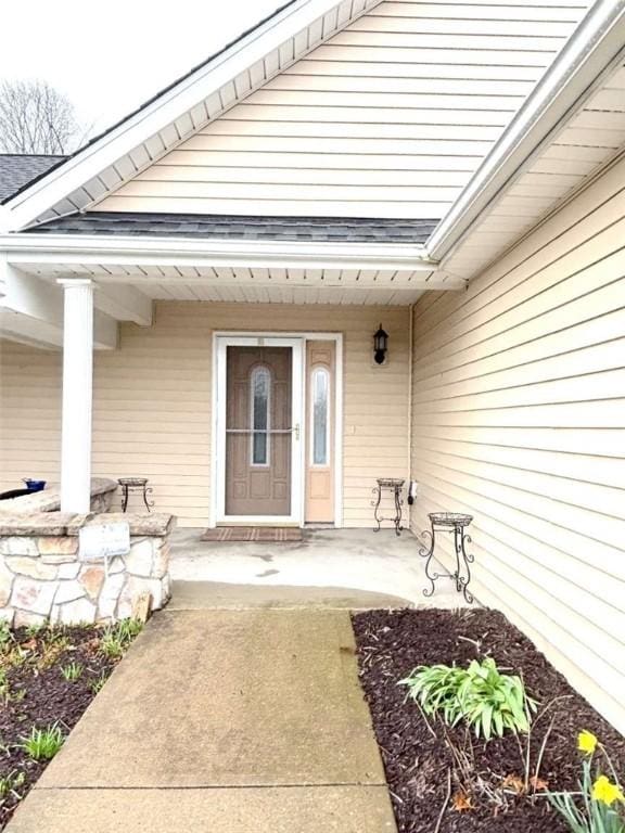 property entrance with a shingled roof