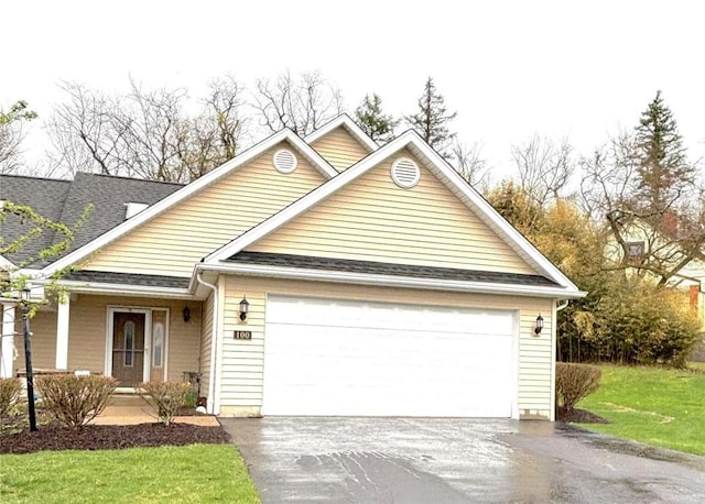 view of front of property with driveway, an attached garage, a front yard, and roof with shingles