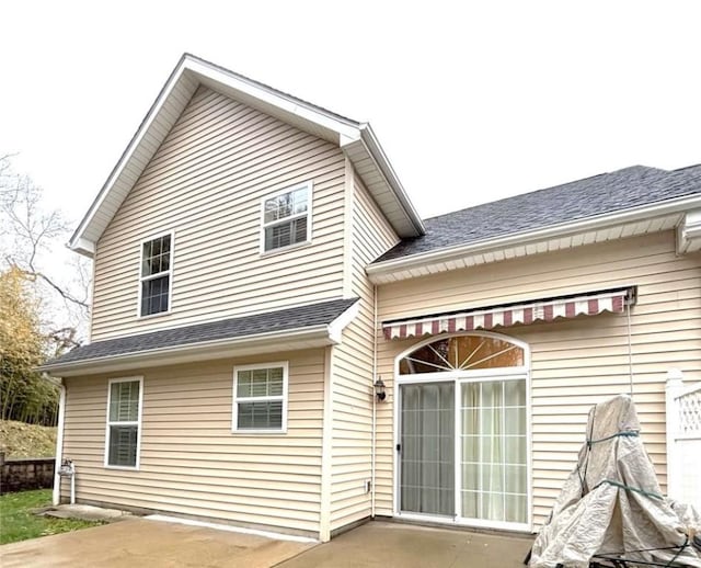 back of house with a patio area and roof with shingles