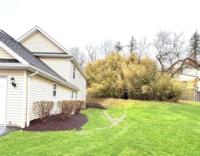 view of green lawn featuring a garage