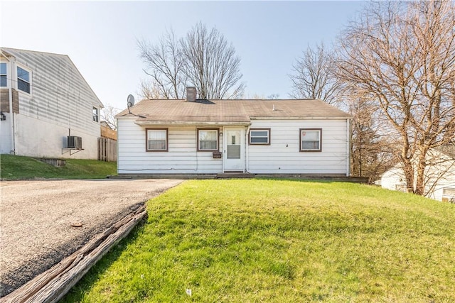 1028 Woodland Ave, Port Vue, PA 15133 - view of front of house with a front lawn, a chimney, central AC, and asphalt driveway