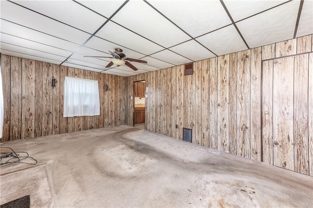 1028 Woodland Ave, Port Vue, PA 15133 - unfurnished living room with wooden walls, ceiling fan, and carpet floors