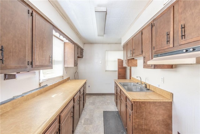 1028 Woodland Ave, Port Vue, PA 15133 - kitchen featuring a sink, under cabinet range hood, light countertops, and brown cabinets
