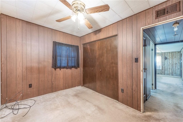 1028 Woodland Ave, Port Vue, PA 15133 - unfurnished bedroom with carpet, wooden walls, a closet, and ceiling fan