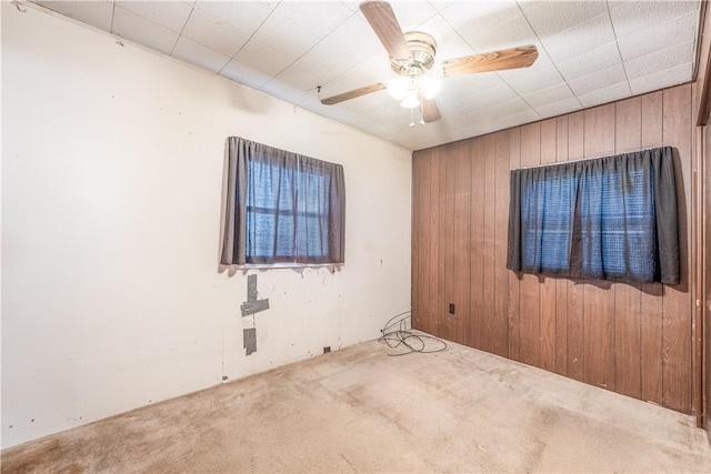 1028 Woodland Ave, Port Vue, PA 15133 - carpeted empty room with wood walls and a ceiling fan