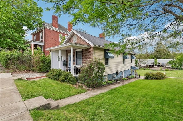 199 Latimer Ave, North Strabane, PA 15363 - view of front of house featuring covered porch, a front lawn, a chimney, and brick siding