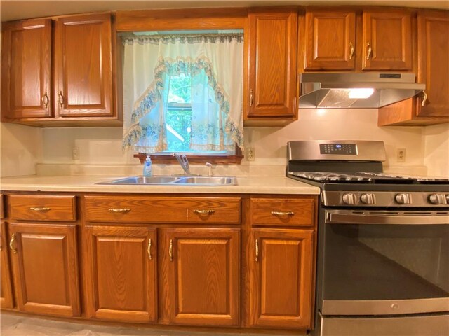 1196 Rutledge Rd, Pymatuning Twp, PA 16154 - kitchen with stainless steel range with gas stovetop, under cabinet range hood, a sink, light countertops, and brown cabinets