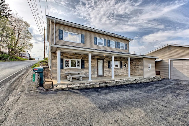 190 W Main St, Donegal Wml, PA 15628 - view of front of property featuring stone siding, a porch, driveway, and a garage