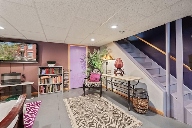 living area with a paneled ceiling, stairway, and recessed lighting