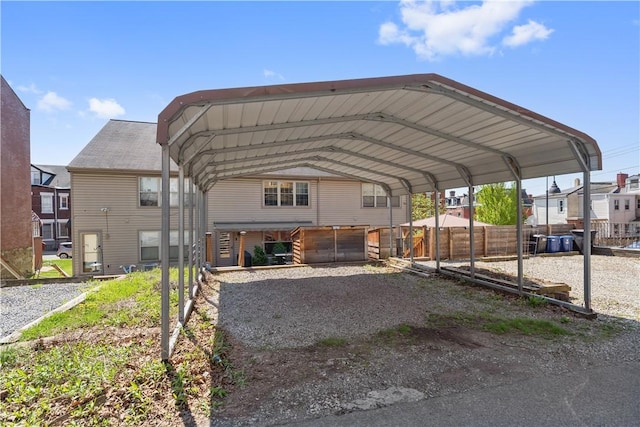 view of parking / parking lot with a carport and fence