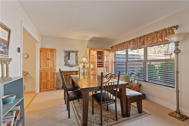 dining area with light colored carpet and baseboards