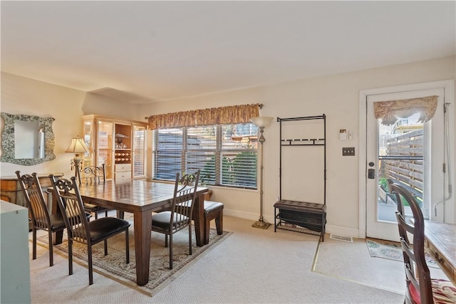 dining area with light colored carpet and baseboards