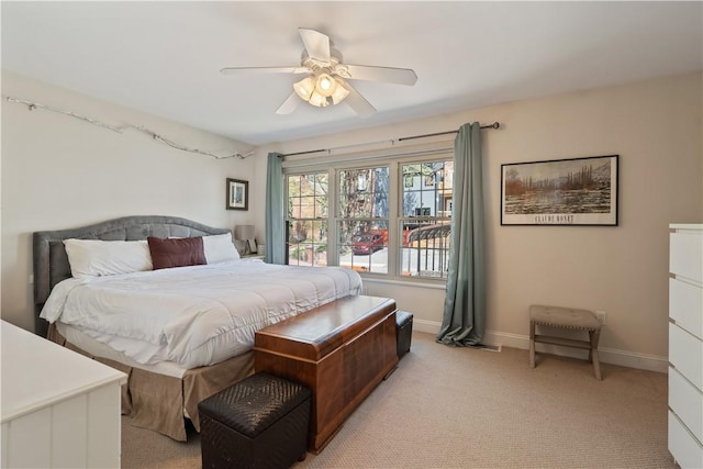 bedroom with light colored carpet, baseboards, and a ceiling fan