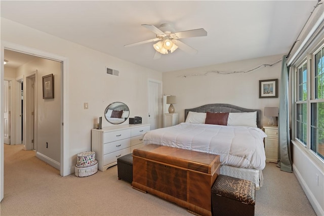 bedroom featuring light colored carpet, a ceiling fan, and baseboards