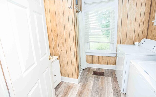 969 Water St, Indiana Boro, PA 15701 - clothes washing area featuring washing machine and clothes dryer, wood walls, light wood finished floors, and baseboards