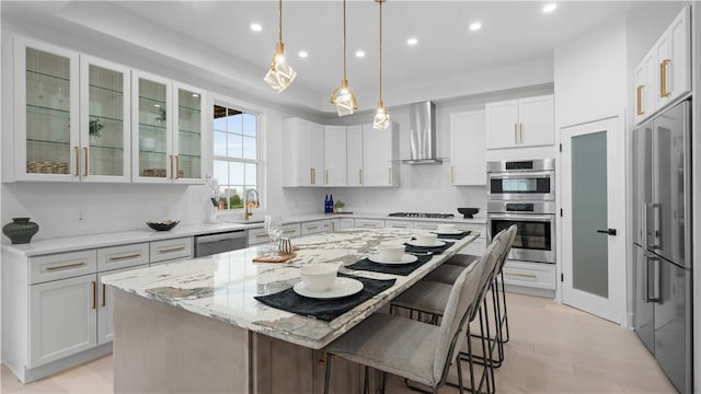 130 Prospect St, Mt Washington, PA 15211 - kitchen with wall chimney range hood, stainless steel appliances, white cabinets, a breakfast bar area, and recessed lighting