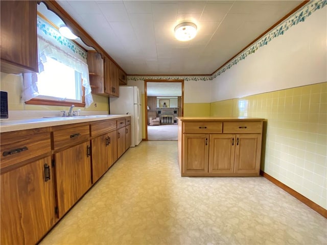35 Kenmore Rd, West Salem Twp, PA 16125 - kitchen featuring freestanding refrigerator, a sink, tile walls, light floors, and brown cabinets