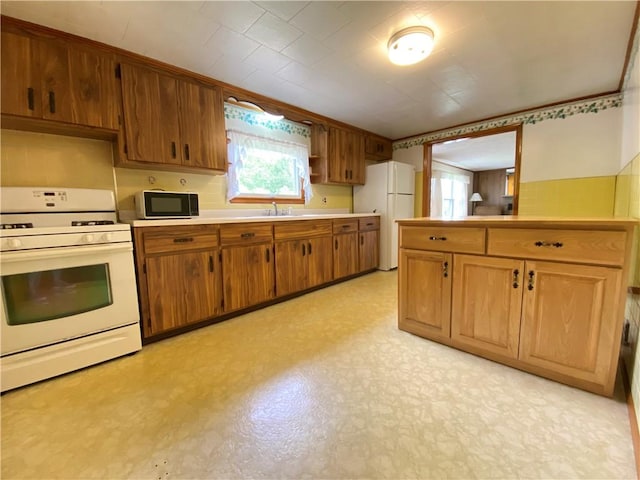 35 Kenmore Rd, West Salem Twp, PA 16125 - kitchen with white appliances, a sink, light countertops, light floors, and brown cabinetry