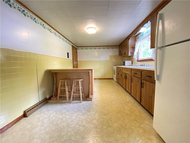 35 Kenmore Rd, West Salem Twp, PA 16125 - kitchen with white appliances, a baseboard heating unit, brown cabinets, light flooring, and light countertops