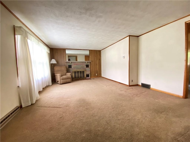35 Kenmore Rd, West Salem Twp, PA 16125 - unfurnished living room with carpet flooring, a fireplace, baseboards, ornamental molding, and a textured ceiling