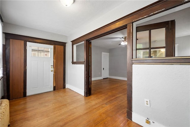 foyer with light wood-type flooring, ceiling fan, radiator heating unit, and baseboards