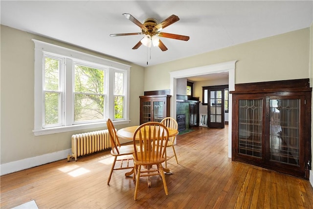 dining space with radiator heating unit, a fireplace, healthy amount of natural light, and baseboards