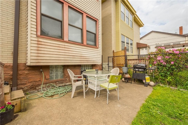 view of patio / terrace featuring fence, outdoor dining area, and a grill