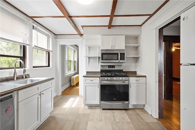 kitchen with stainless steel appliances, open shelves, radiator heating unit, a sink, and dark countertops